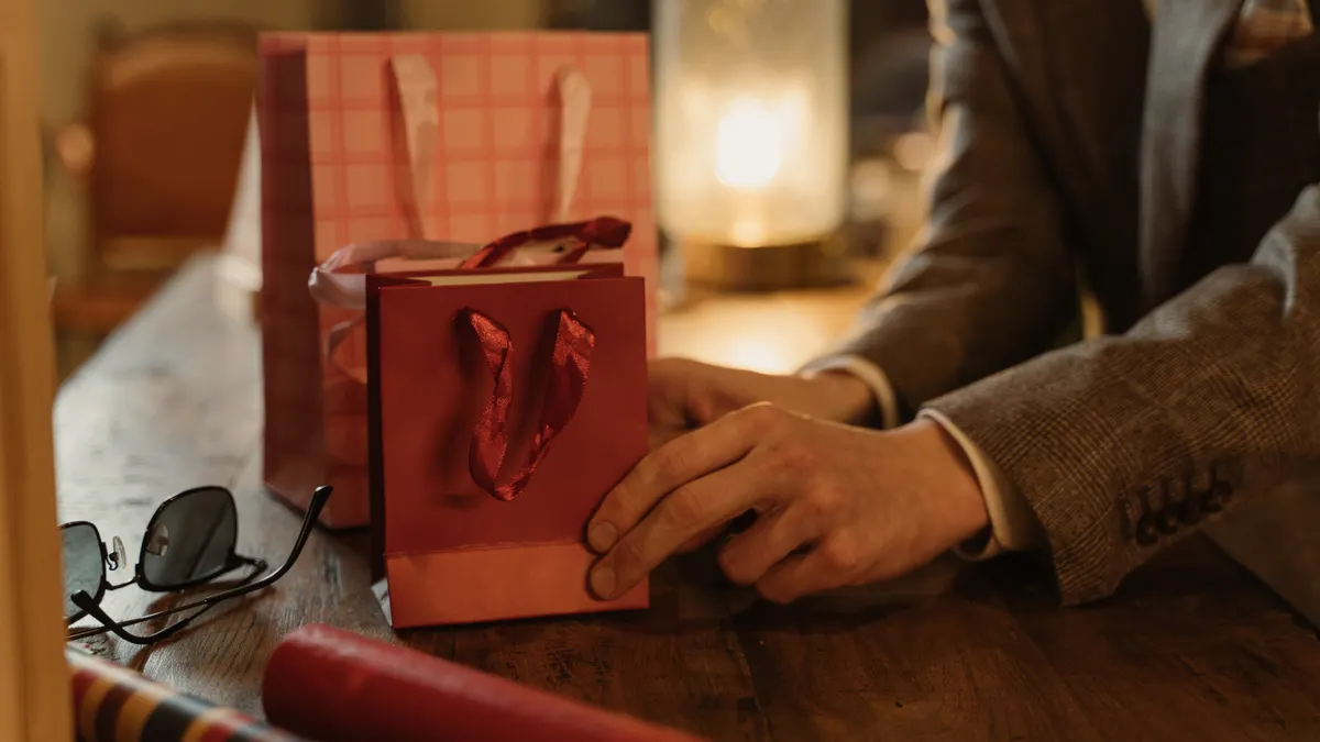 person holding a small red gift bag